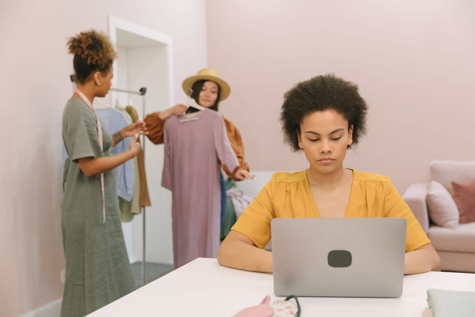 A woman works on a laptop at a table, browsing software deals