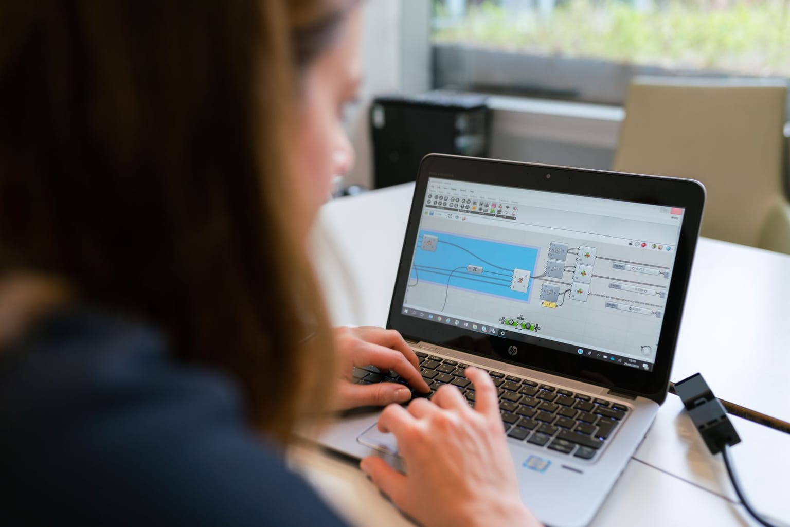 A person using a laptop with a visual programming interface open on the screen, working on workflow automation and app integration