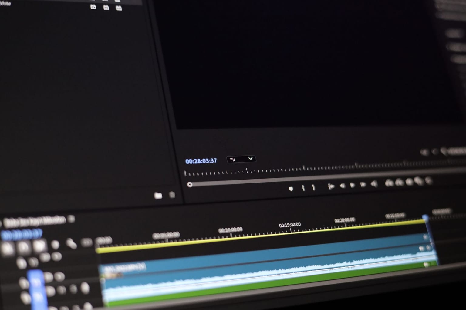 A close-up of a computer screen displaying a video editing software interface, showing multiple audio and video tracks on a timeline—a perfect setup