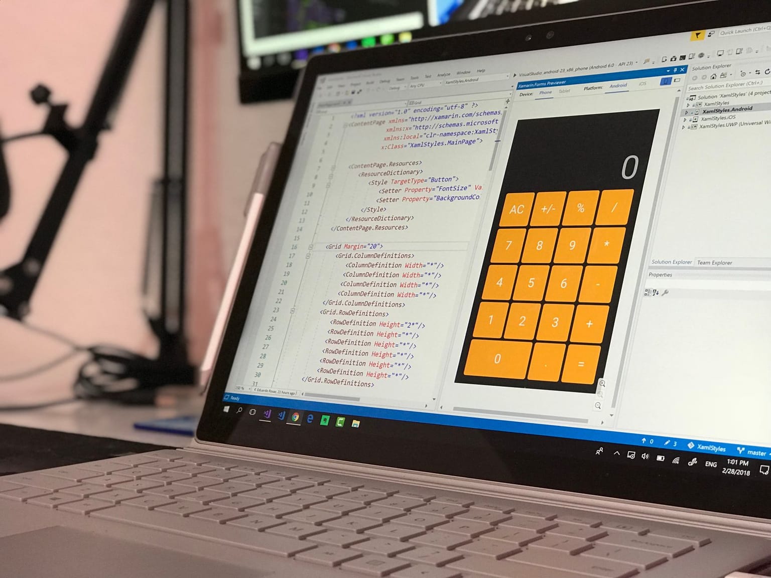 A laptop screen displays code for a calculator app using free software tools in a development environment