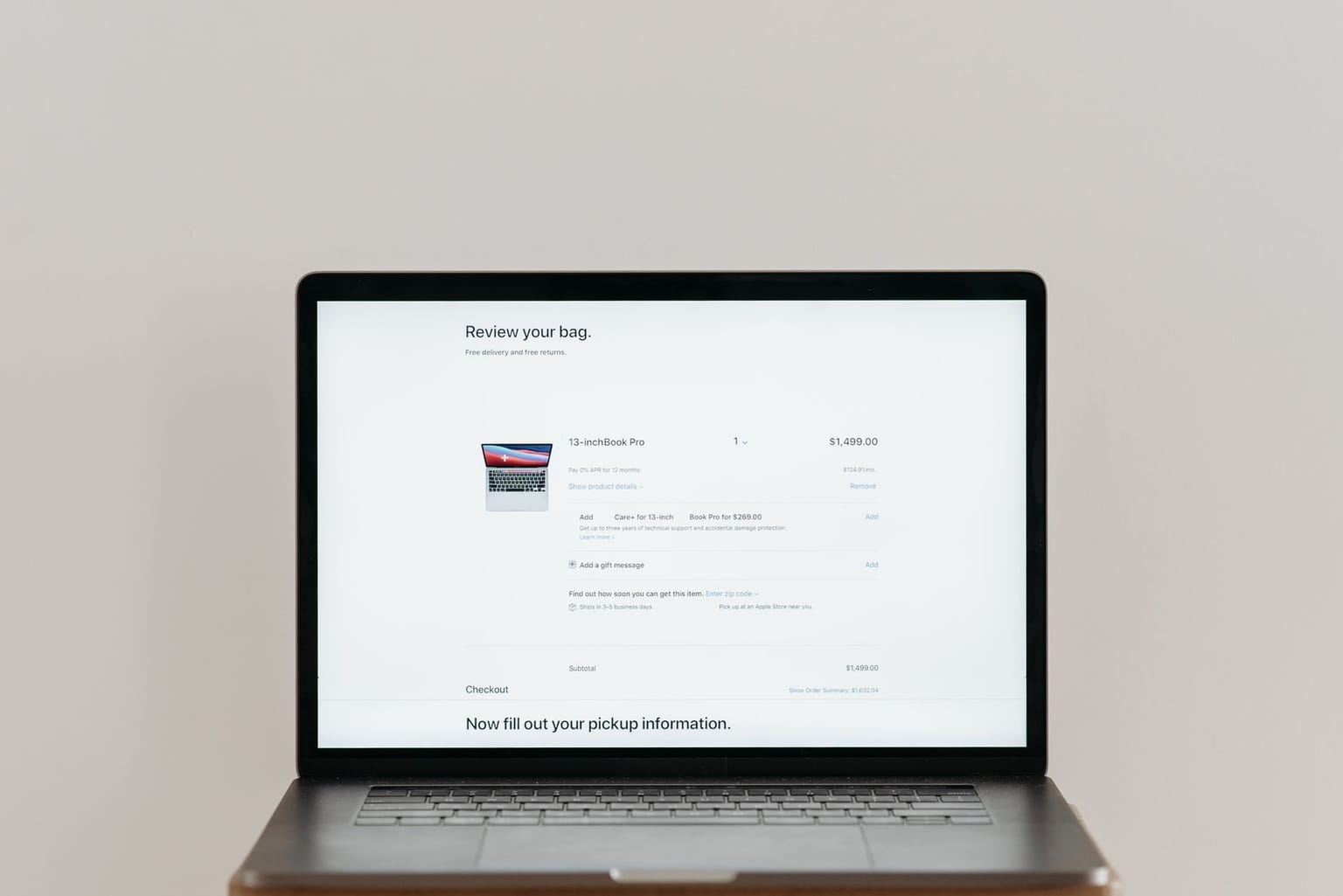 A laptop screen displays an online checkout page for a MacBook Pro, utilizing checkout software to show the item details, price
