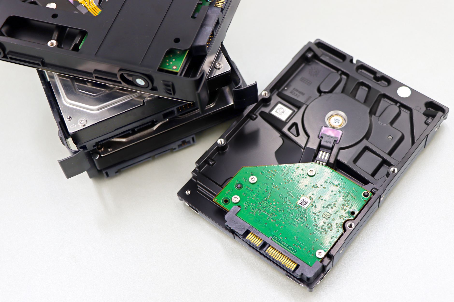 A stack of dismantled hard disk drives on a white surface, the hardware a lifetime cloud plan ultimately rests on