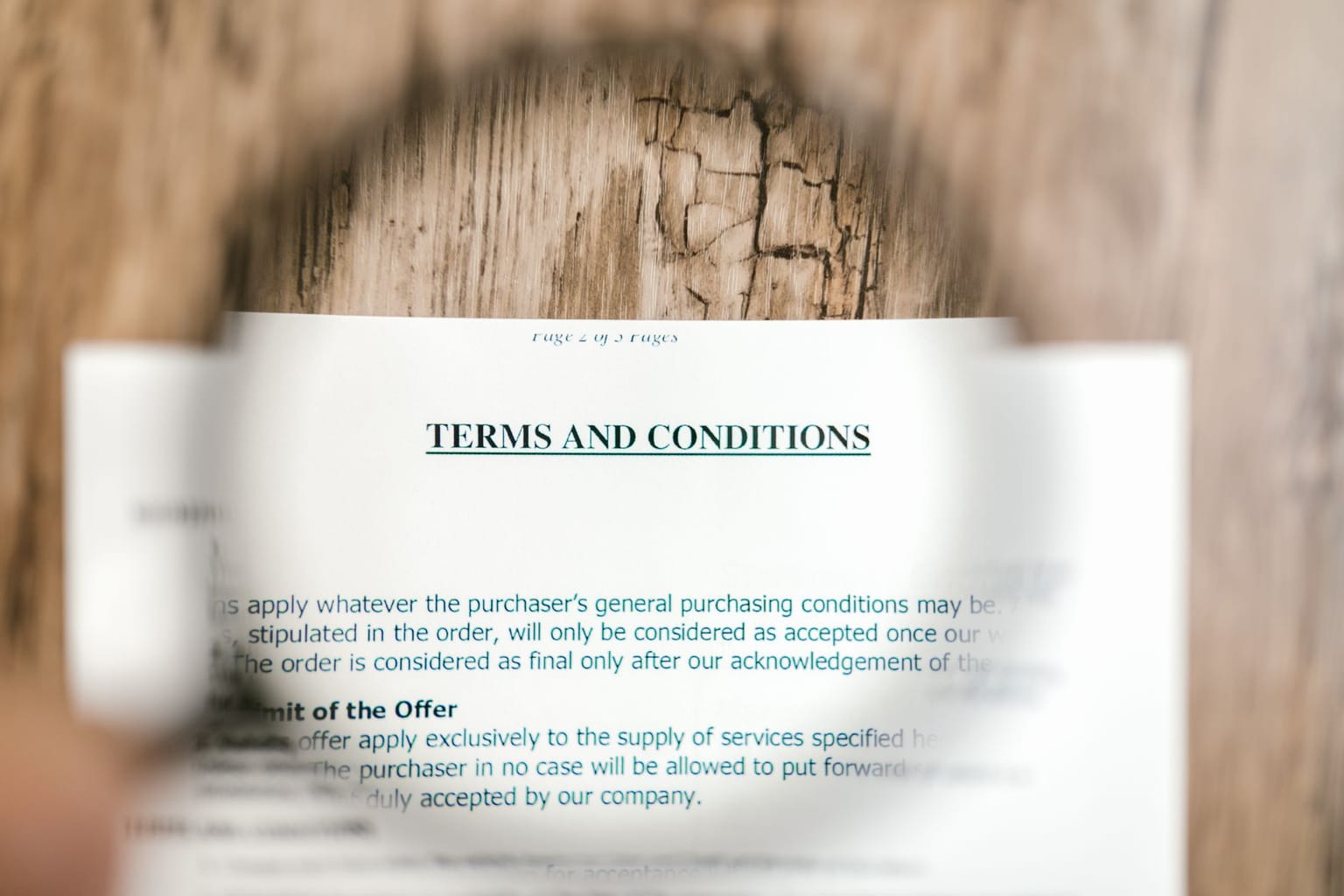A magnifying glass over a Terms and Conditions document, with the fine print in focus