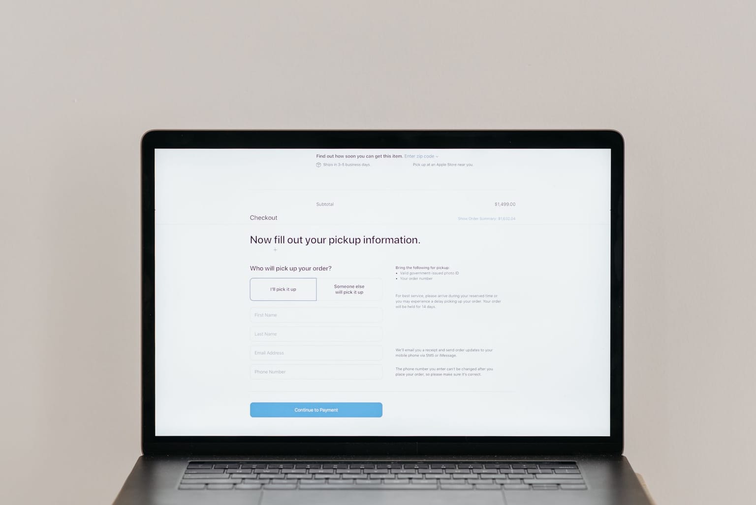 A laptop screen displays an online checkout page for buying software online, asking the user to fill out their information